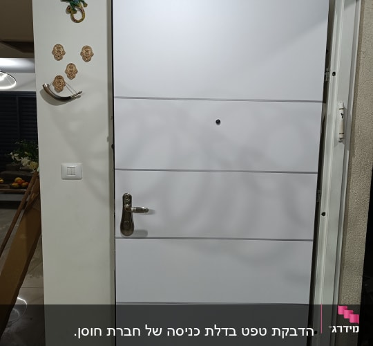 דלת לבנה עם ידית מתכת ועינית